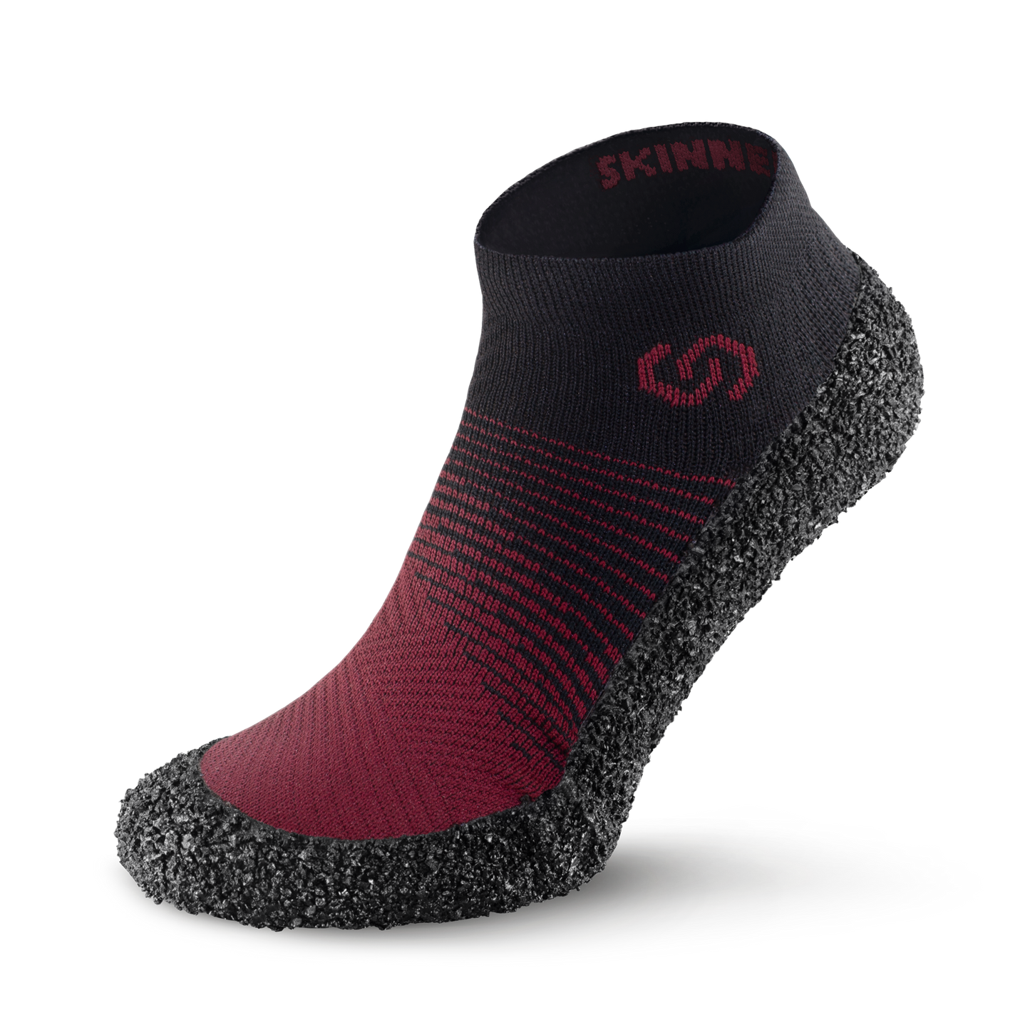 Back view of Skinners sock shoe with a red fabric upper and a textured black rubber sole.